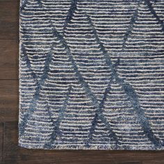 a blue and white rug on top of a wooden floor