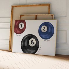 three pool balls are sitting next to each other in front of a white wall and wooden frame