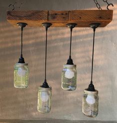 four mason jar lights hanging from a wooden beam