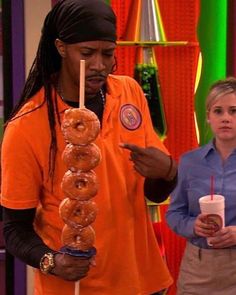 the young man is holding a donut on a stick