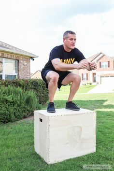 a man sitting on top of a wooden box