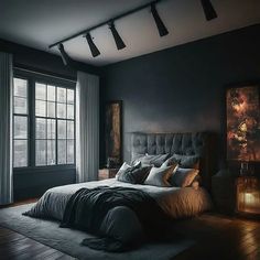 a bedroom with black walls and wooden floors, large bed in the center surrounded by two windows