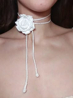 a close up of a woman wearing a white rose choker necklace with braids