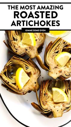 grilled artichokes on a plate with lemon wedges