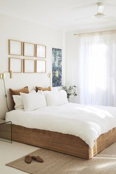 a bed with white sheets and pillows in a bedroom