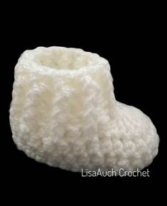 a white crocheted boot is shown against a black background