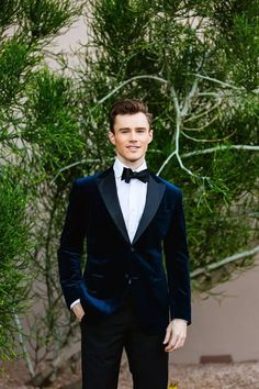 a man in a tuxedo poses for the camera