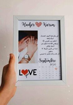 a person holding up a framed photo with the words love written on it