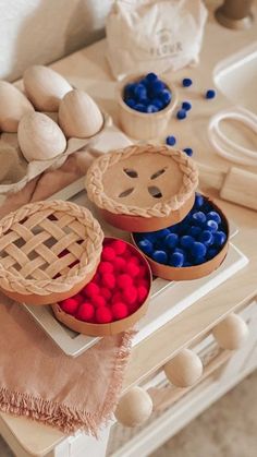 three pies with red, white and blue toppings on a table next to doughnut holes