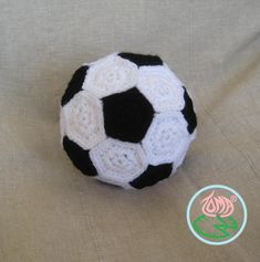 a black and white crocheted soccer ball sitting on top of a tan cloth