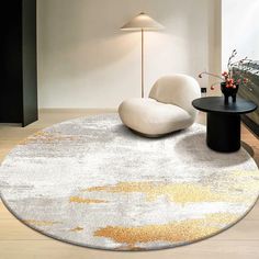 a living room with white and gold rugs on the floor next to a black table