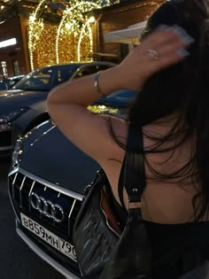 a woman with her back to the camera in front of some cars