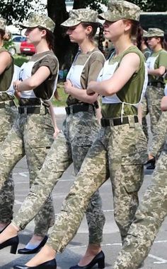 women in uniform marching down the street with their hands behind their back legs and feet crossed