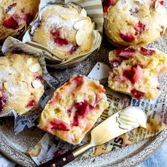 strawberry muffins with powdered sugar on top are sitting on a glass plate