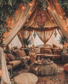 a living room filled with lots of furniture under a canopy covered in plants and lights