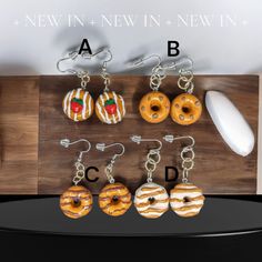 six doughnuts are hanging from hooks on a wooden board with the letters abc, c, and d