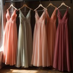 four bridesmaid dresses hanging up in a row