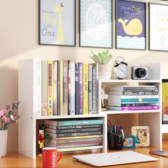 a computer desk with books and pictures on the wall