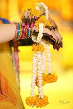 a woman holding flowers and bracelets in her hands