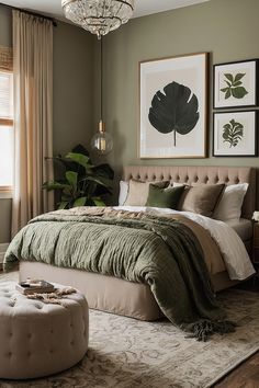 a bedroom with a large bed and pictures on the wall above it, along with a footstool