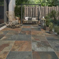 a porch with a swing, rocking chair and potted plants