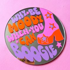 a round metal sign with the words, why be moody when you can boogie