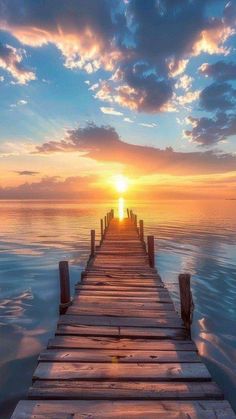 the sun is setting over the water on a dock in the middle of the ocean