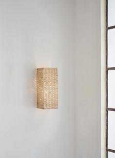 a wall light that is on the side of a wall in a room with white walls