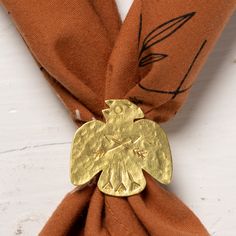 an orange scarf with a gold brooch on it