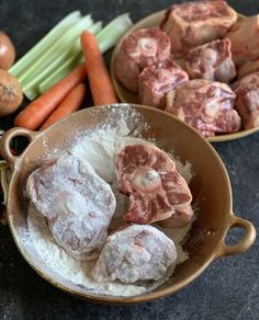 some meat and vegetables are in bowls on the table