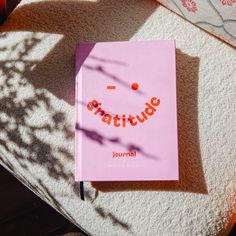 a pink book sitting on top of a white rug