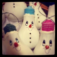 a group of white bowling pins with faces painted on them, all lined up together