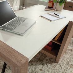 an open laptop computer sitting on top of a white desk