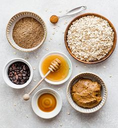 bowls filled with oatmeal, peanut butter and honey next to other ingredients