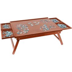 a wooden table with two trays on it and blue flowers painted on the top