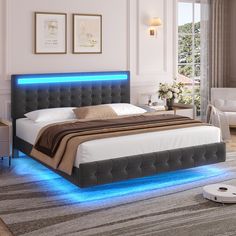 a bed with blue lights on the headboard and foot board is in a white room