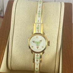 Vintage 1950's Flip Top Bucherer 17 Jewels Swiss Ladies Floral Enameled Cuff Wrist Watch 18k Heavy Gold 10 Micron Gold Plated Marked By Inside Back Underside 12 O'clock. Hinged Case Lid Stays Tightened. This Bucherer Watch Has A Larger Crown, Runs, Hand Wind, Gold Fleur D'alain, Raised Green Dots, Cream Enamel. Has A New Crystal, There Are Some Very Light Scuffs To Bracelet It Has Good Springs And Can Fit Up To A Size 6.85 Marked 36u C-Cr Excellent Condition As All Vintage Watches Slight Variation In Time Keeping Can Be Off Tested For 8 Hours Keeping Time Womens Watches Vintage, Vintage Yellow Gold Watch With Bracelet Strap, White Retro Watch For Formal Occasions, Retro White Watches For Formal Occasions, White Retro Formal Watch, White Retro Formal Watches, Italy Outfits, Cuff Watch, Green Dot