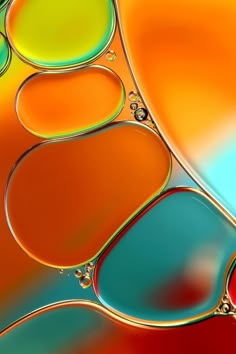 an image of colorful liquid drops in the middle of a glass plate with red, green and blue colors