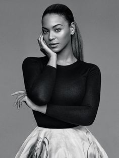 a black and white photo of a woman in a skirt