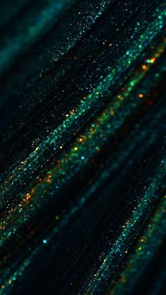 green and gold glitters are seen in this image from the bottom down on a black background