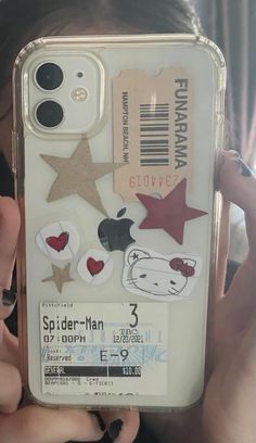 someone is holding up their phone case with stickers on it, and there are other things in the case