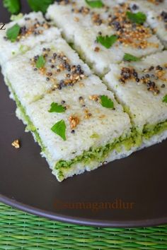 some food that is on a black plate with green leaves and sprinkles