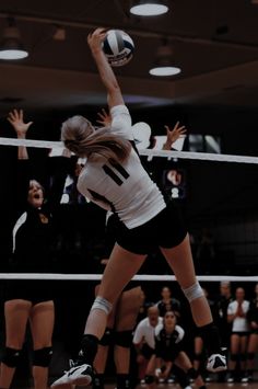 a volleyball player jumping up to hit the ball