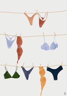 several bras hanging on a line with clothes pins in the shape of women's bras