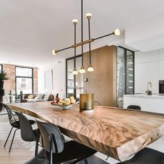 a wooden table sitting in the middle of a living room next to a dining room