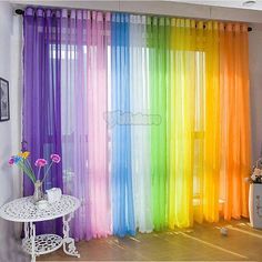 the room is decorated with colorful sheer curtains