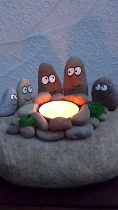 a rock with some rocks sitting on top of it next to a lit candle in the middle