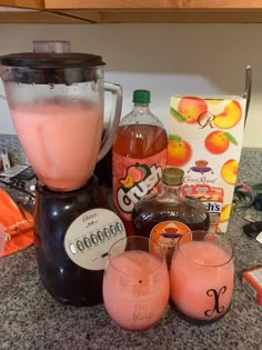 a blender filled with liquid sitting on top of a counter next to two glasses