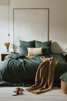 a bed with green sheets and pillows in a bedroom