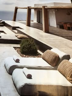 an outdoor lounge area with cushions and plants